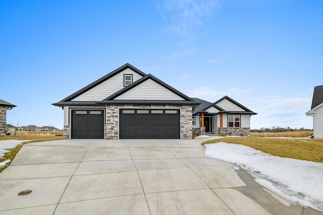 view of front of house with a garage, stone siding, and concrete driveway