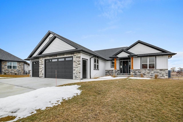 view of front facade with a front yard, stone siding, driveway, and an attached garage