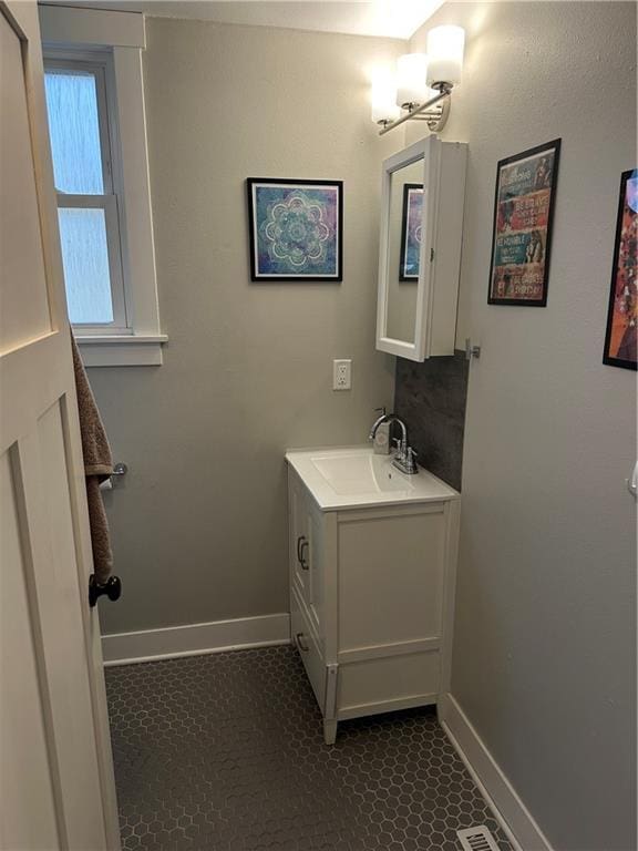 bathroom with vanity, baseboards, and tile patterned floors