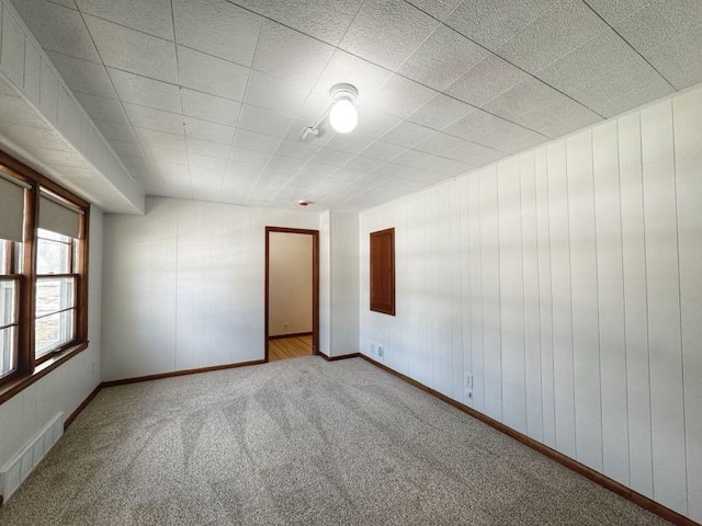 spare room with baseboards, visible vents, and carpet flooring