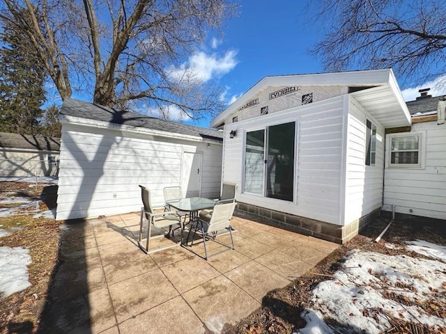 rear view of house with outdoor dining space, an outdoor structure, and a patio