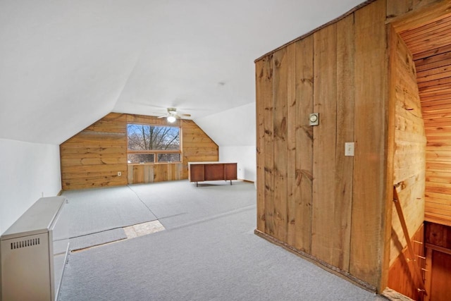 bonus room with lofted ceiling, ceiling fan, carpet flooring, and wooden walls