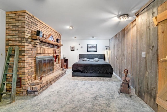 bedroom with wood walls, carpet, and a fireplace