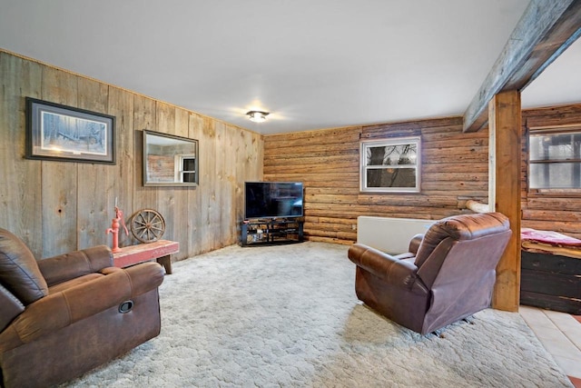 living area with carpet and beam ceiling