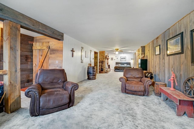 living room featuring carpet floors, wood walls, and a ceiling fan