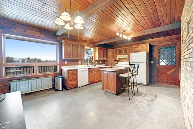 kitchen with white appliances, light countertops, beam ceiling, a center island, and radiator