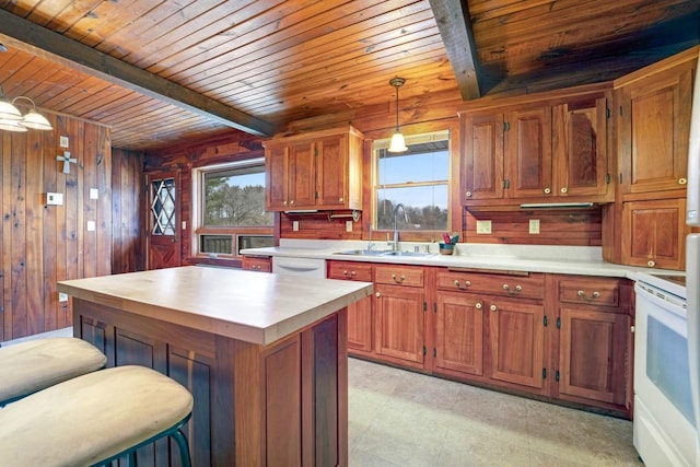 kitchen featuring white appliances, wood walls, a sink, and beamed ceiling