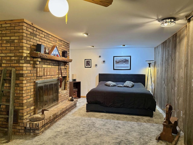 carpeted bedroom featuring a brick fireplace, visible vents, and ceiling fan