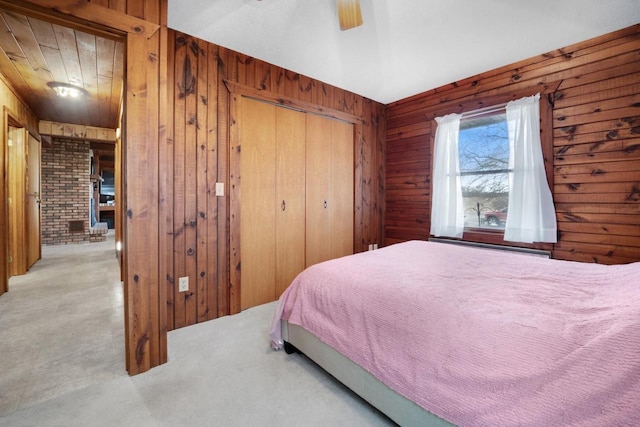 bedroom featuring wood walls, a closet, and a ceiling fan