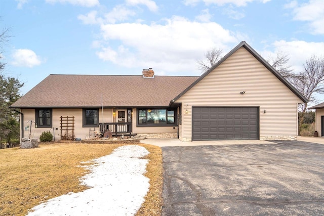 view of front of home featuring a garage, roof with shingles, a chimney, and aphalt driveway