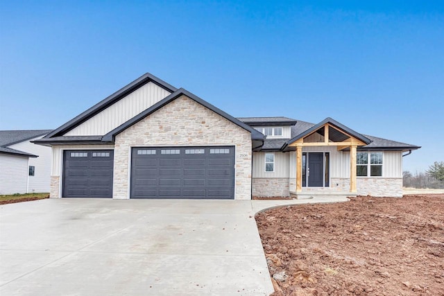 craftsman house with a garage, stone siding, driveway, and board and batten siding