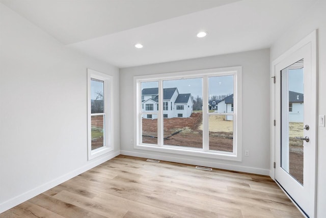 interior space with light wood-style floors, recessed lighting, visible vents, and baseboards