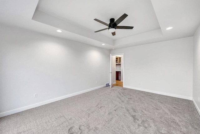 carpeted spare room with baseboards, a raised ceiling, a ceiling fan, and recessed lighting