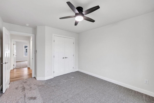 unfurnished bedroom featuring carpet floors, ceiling fan, baseboards, and a closet