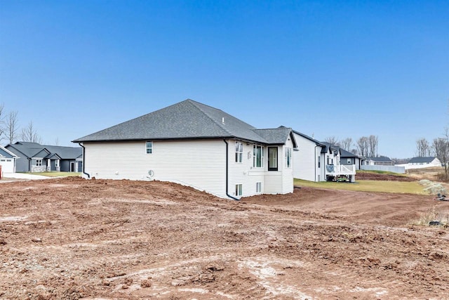 view of property exterior featuring a residential view and roof with shingles