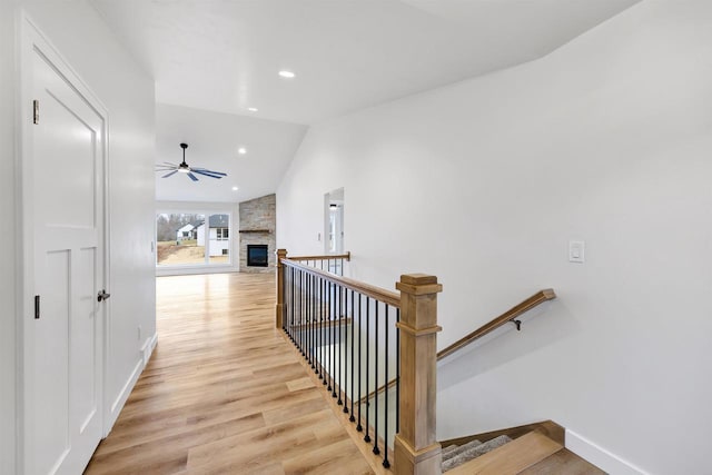 interior space featuring baseboards, vaulted ceiling, an upstairs landing, light wood-type flooring, and recessed lighting