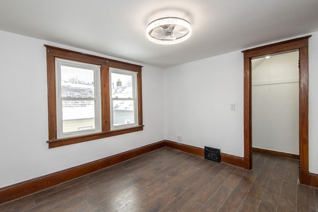 unfurnished bedroom featuring dark wood-style flooring, a closet, and baseboards