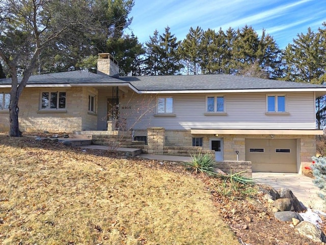 view of front of home featuring a garage, stone siding, a chimney, and concrete driveway