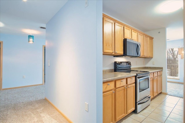 kitchen featuring stainless steel appliances, light countertops, visible vents, light carpet, and baseboards