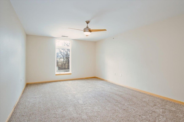 empty room with baseboards, carpet floors, visible vents, and a ceiling fan