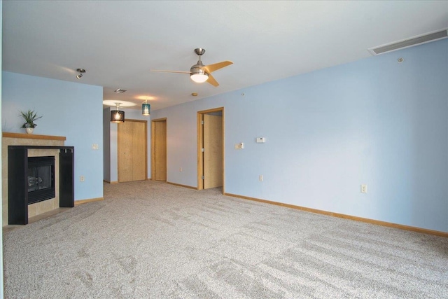 unfurnished living room featuring carpet, visible vents, a tiled fireplace, a ceiling fan, and baseboards