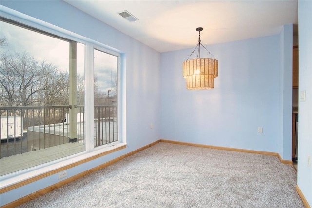 empty room featuring carpet flooring, visible vents, and baseboards