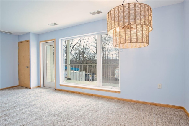 carpeted spare room featuring visible vents and baseboards