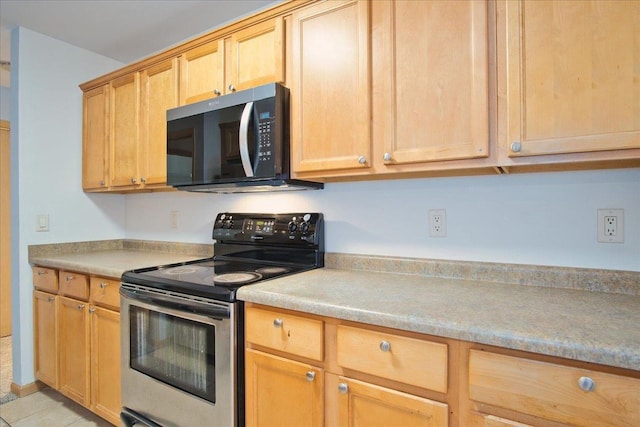 kitchen with light tile patterned floors, light countertops, light brown cabinetry, and stainless steel electric range