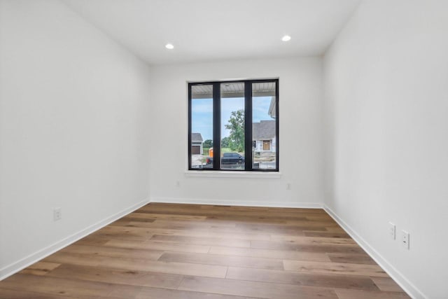 empty room featuring baseboards, wood finished floors, and recessed lighting