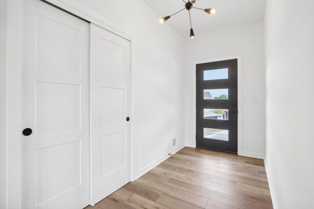 foyer featuring light wood-style flooring and baseboards
