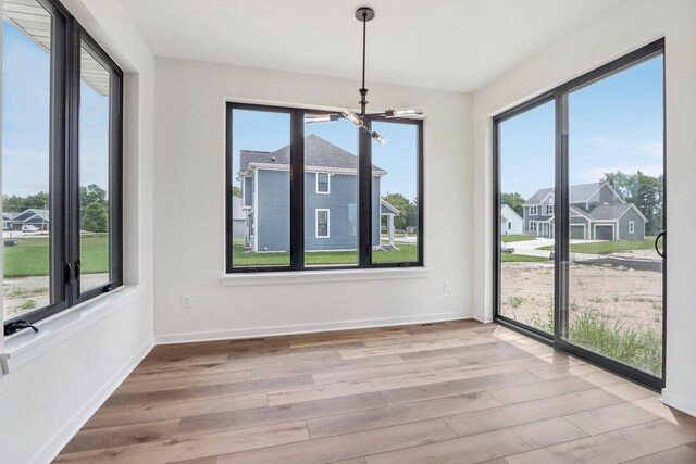 interior space with a notable chandelier, baseboards, and wood finished floors