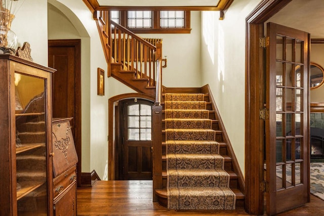 stairs with baseboards and arched walkways