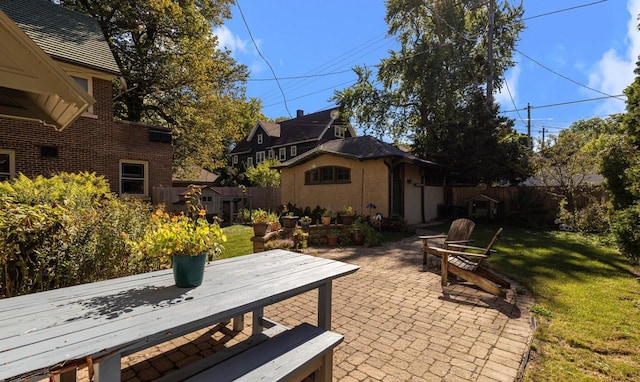 view of patio with an outbuilding and fence