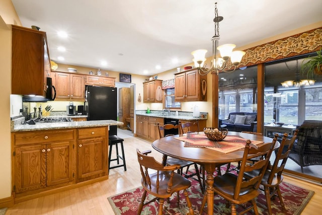 dining area with a chandelier, recessed lighting, and light wood-style flooring