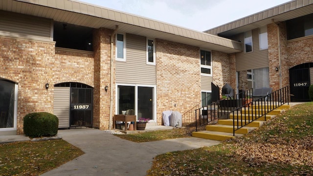 doorway to property featuring brick siding