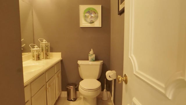 half bathroom featuring vanity, toilet, and tile patterned floors