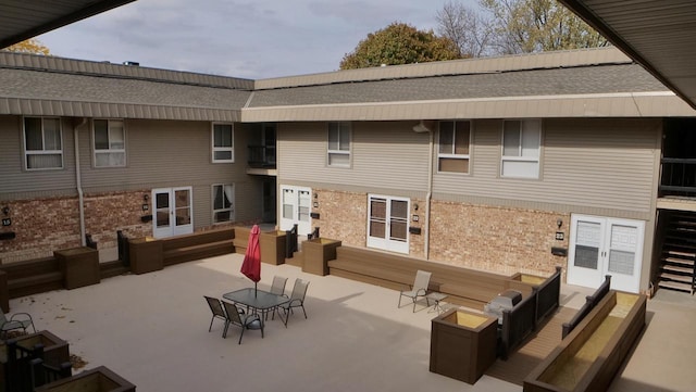 back of house featuring brick siding and a patio