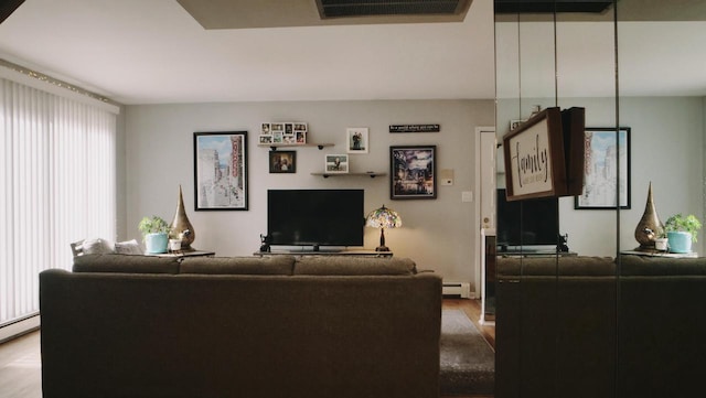 living room with a baseboard heating unit and visible vents