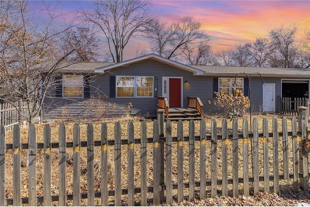 view of front of property featuring an attached garage and a fenced front yard