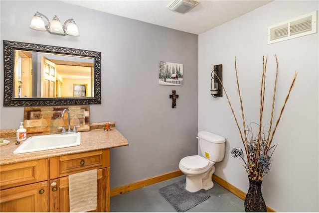 bathroom with vanity, toilet, baseboards, and visible vents