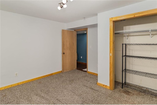 unfurnished bedroom with baseboards, carpet floors, and a closet