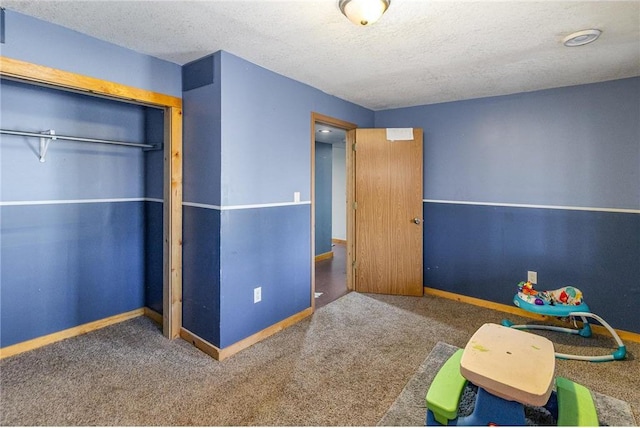 unfurnished bedroom with a closet, baseboards, a textured ceiling, and carpet flooring