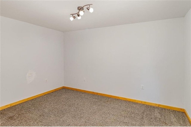 empty room featuring baseboards and carpet flooring