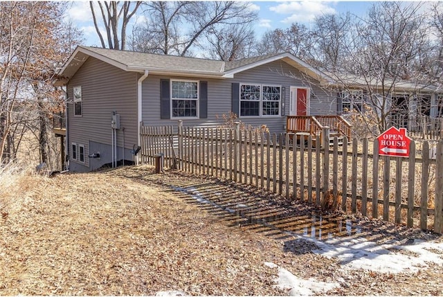 view of front of property with a fenced front yard and a shingled roof