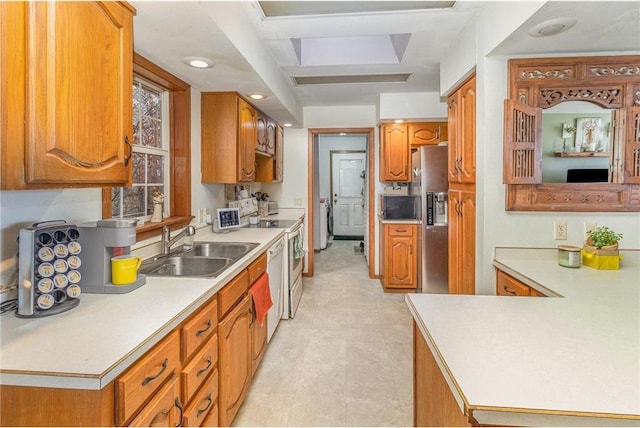 kitchen with white appliances, recessed lighting, a sink, light countertops, and brown cabinets