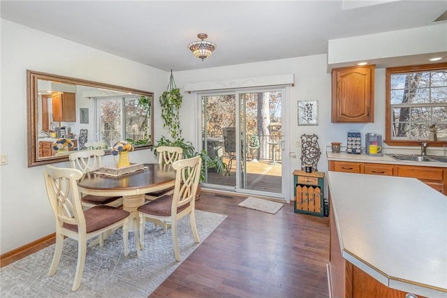 dining space with plenty of natural light, baseboards, and dark wood-style flooring