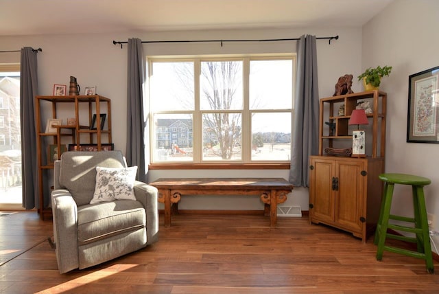 sitting room with baseboards and light wood-style floors