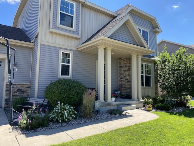 craftsman-style house featuring stone siding, a porch, and board and batten siding