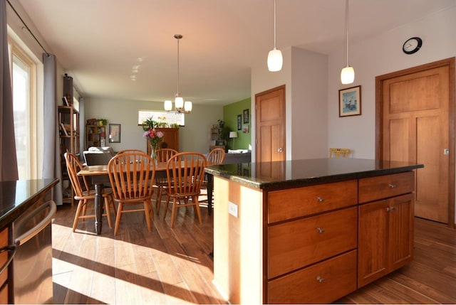 kitchen featuring a notable chandelier, brown cabinetry, dark wood-style flooring, and decorative light fixtures