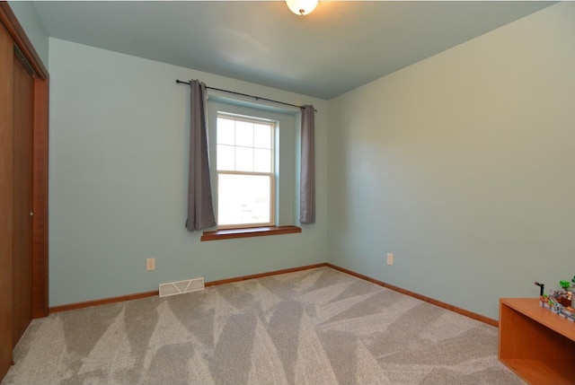 unfurnished bedroom with baseboards, a closet, visible vents, and carpet flooring